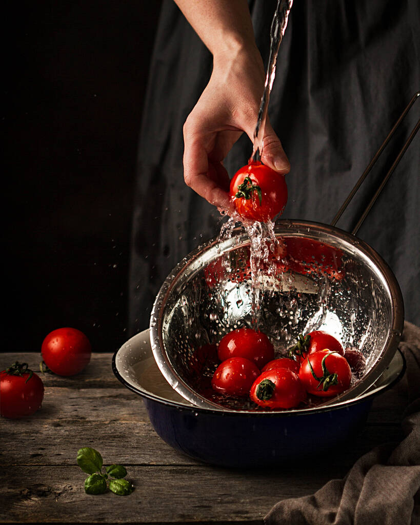 Las manos femeninas lavan los tomates bajo el chorro del agua
. - Foto, imagen