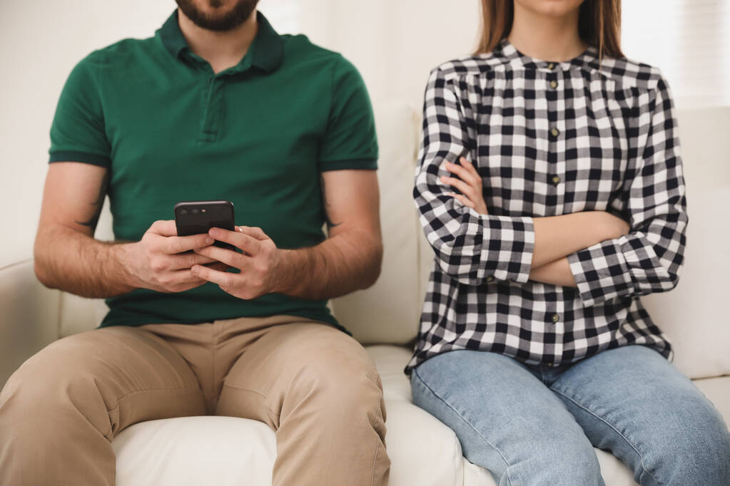 Mladý muž dává přednost smartphonu před svou přítelkyní doma, detailní záběr. Problémy ve vztahu - Fotografie, Obrázek