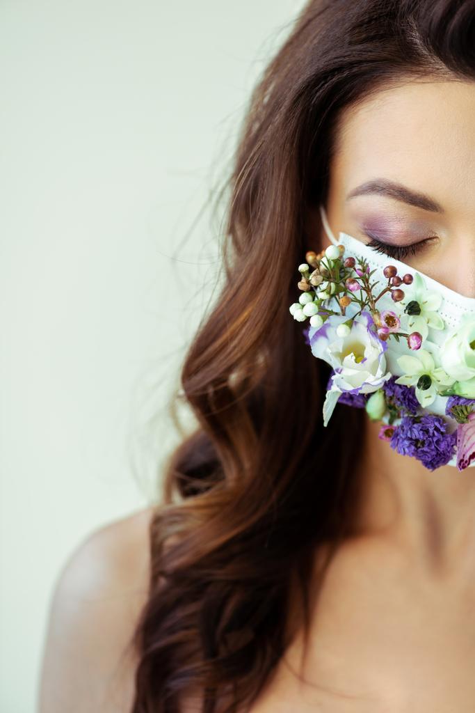 oříznutý pohled na ženu se zavřenýma očima v květinové masce izolované na šedi - Fotografie, Obrázek