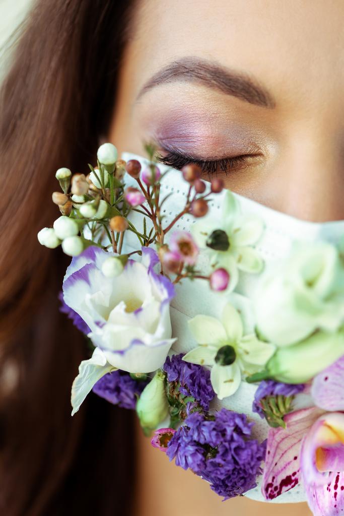 vue recadrée de la femme aux yeux fermés en masque floral
  - Photo, image