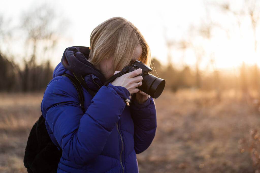 Una fotografa donna tiene in mano una macchina fotografica. Il concetto di una donna fotoreporter
. - Foto, immagini