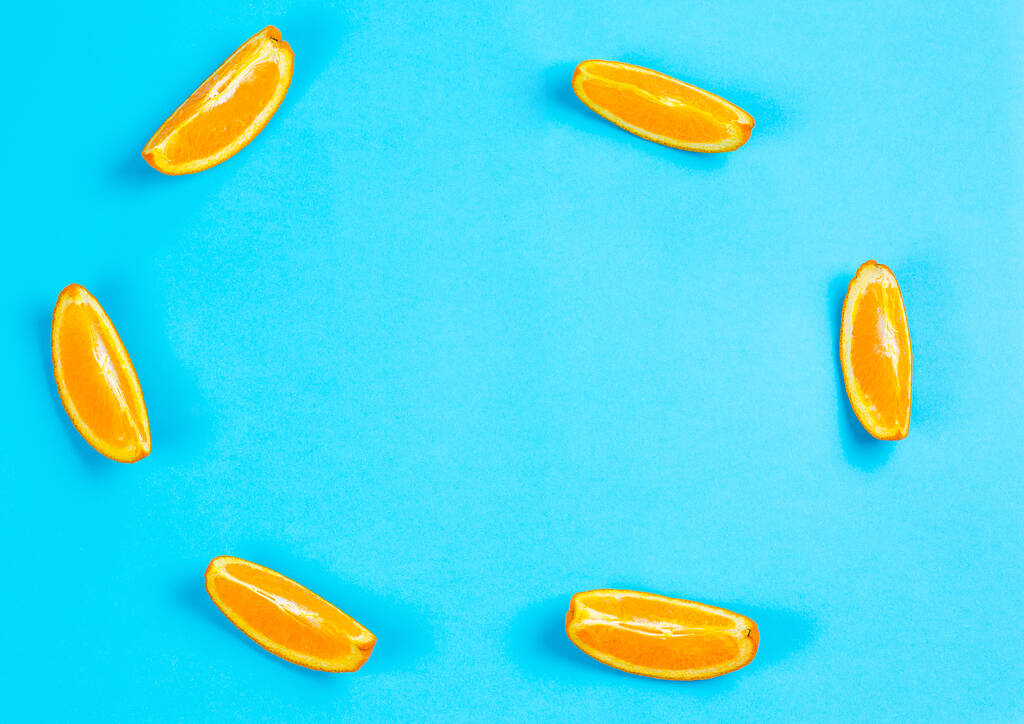 レモネードを作るための青の背景にオレンジのスライス - 写真・画像