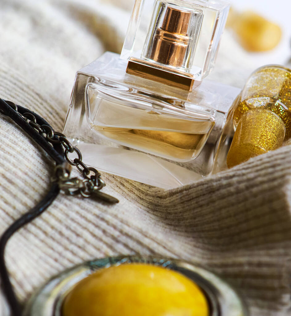 Bodegón con cárdigan, perfume y colgante
 - Foto, Imagen
