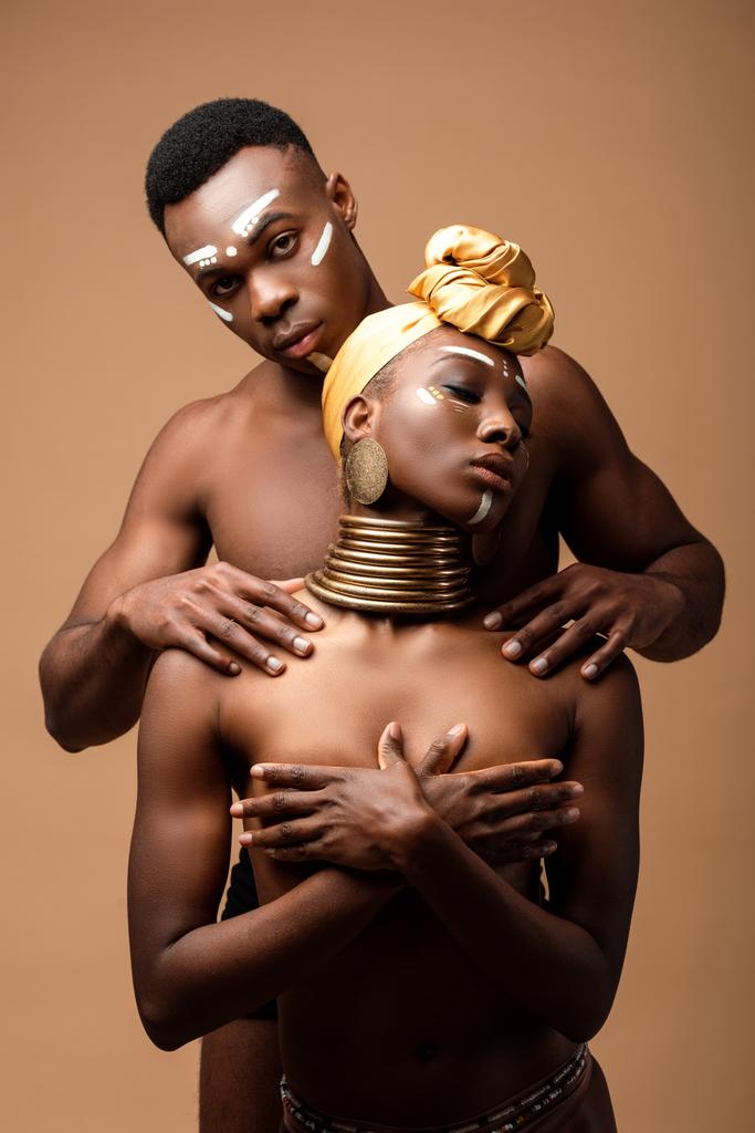 sexy naakt tribal afro paar poseren geïsoleerd op beige - Foto, afbeelding
