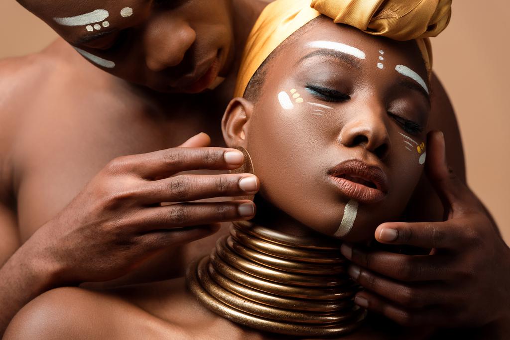 Nahaufnahme von nackten Tribal-Afro-Paar posiert isoliert auf beige - Foto, Bild