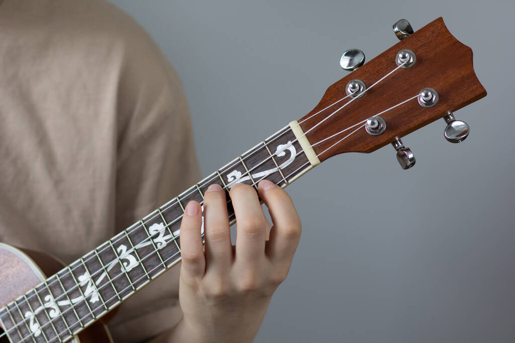Жінка рука грає укулеле на білому тлі
 - Фото, зображення