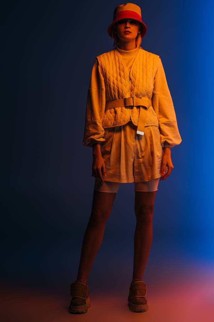 divatos modell pózol futurisztikus megjelenés és kalap sötétkék - Fotó, kép
