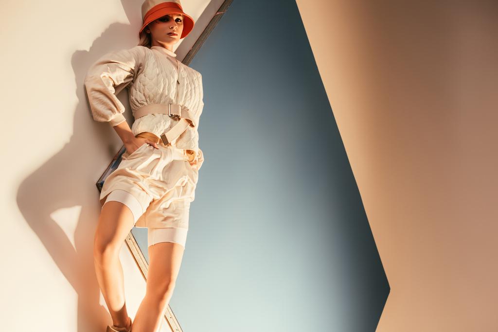 mooi model poseren voor toekomstige fashion shoot op beige en blauw - Foto, afbeelding