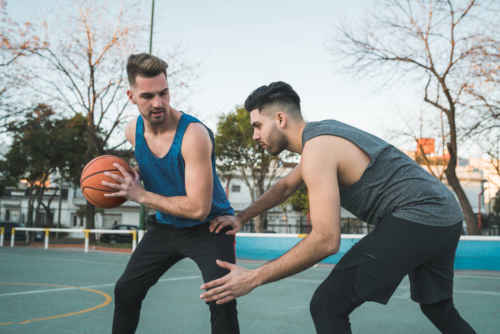 Портрет двох молодих друзів, які грають у баскетбол і розважаються на вулиці. Спортивна концепція
. - Фото, зображення