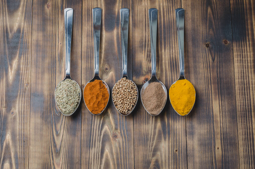 diverses épices dans des cuillères sur une table en bois, vue de dessus Ingrédients pour la cuisine
 - Photo, image