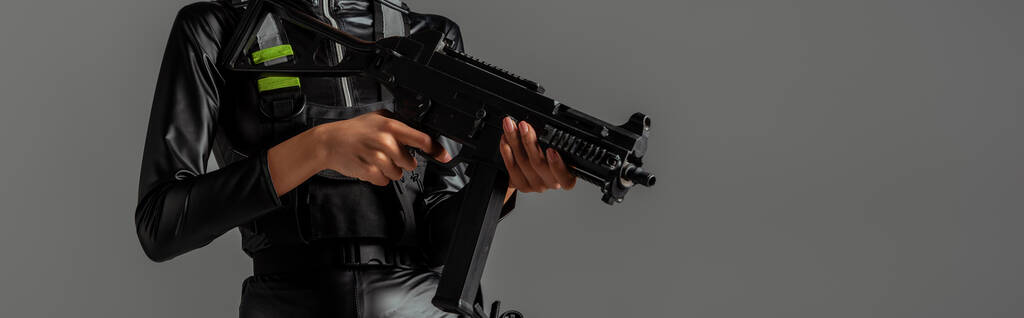 vista cortada de mulher africana futurista americana com rifle de assalto isolado em cinza
 - Foto, Imagem
