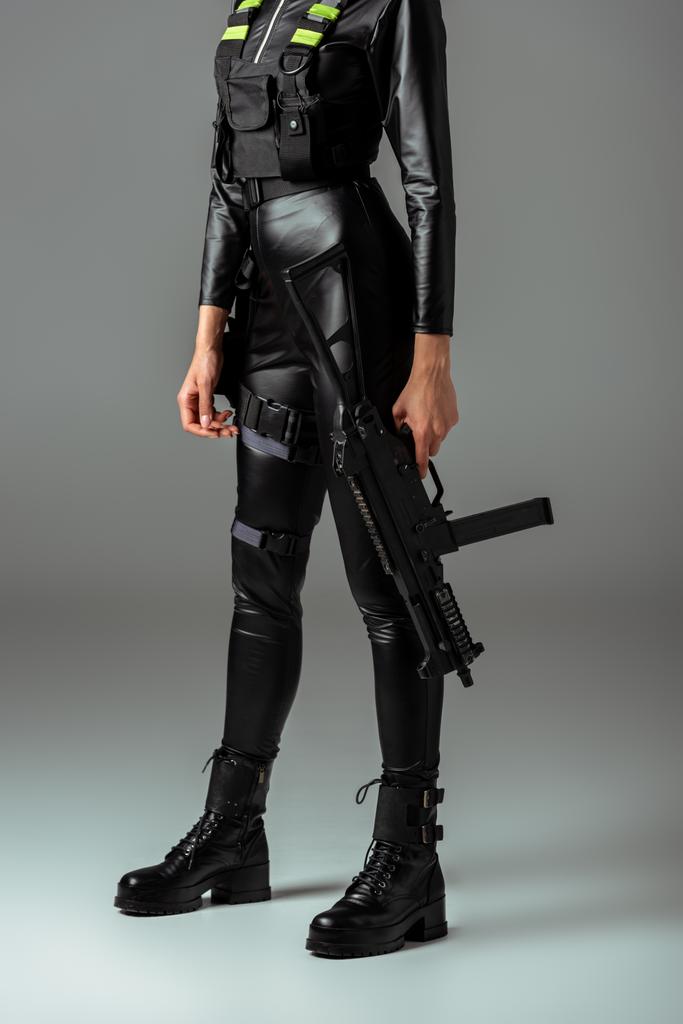 cropped view of futuristic african american woman with assault rifle on grey - Photo, Image