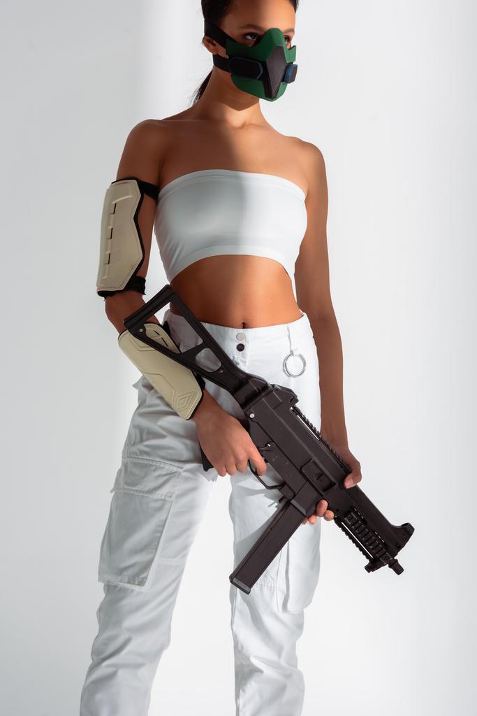 футуристическая американка в защитной маске с автоматом на белом фоне
 - Фото, изображение