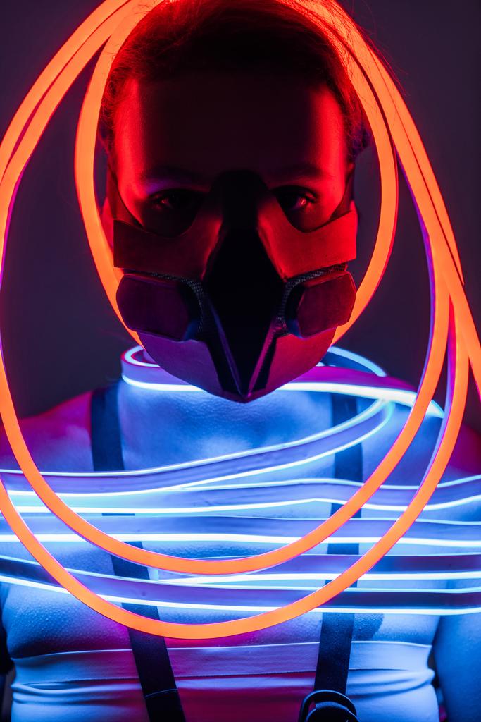 futuristisch Afrikaans amerikaanse vrouw in respirator en neon verlichting - Foto, afbeelding