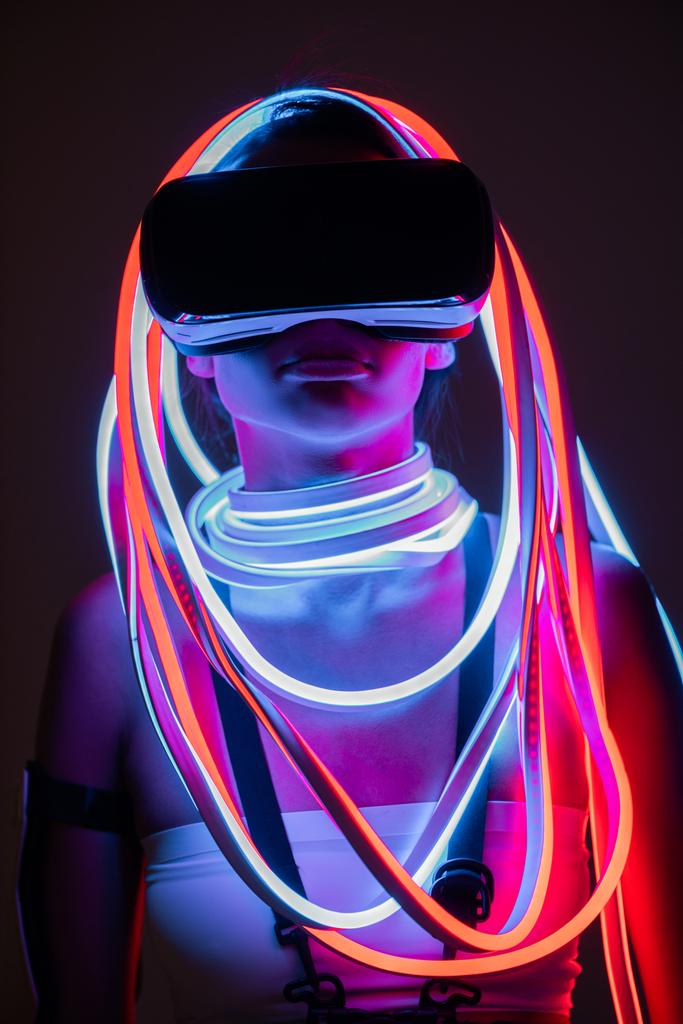 futuristische Afrikaans-Amerikaanse vrouw in vr headset en neon verlichting - Foto, afbeelding