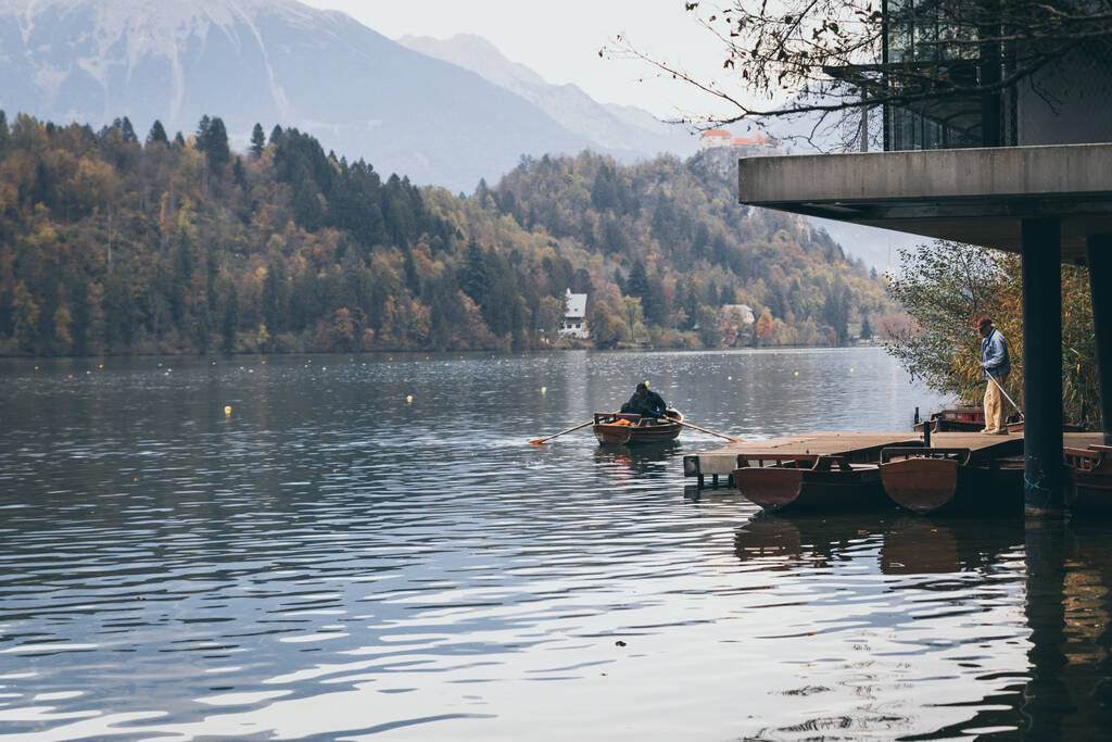 BLED, SZLOVÉNIA - Október, 2019: Emberek lovaglás egy fa hajó a tavon Bled Szlovéniában - Fotó, kép