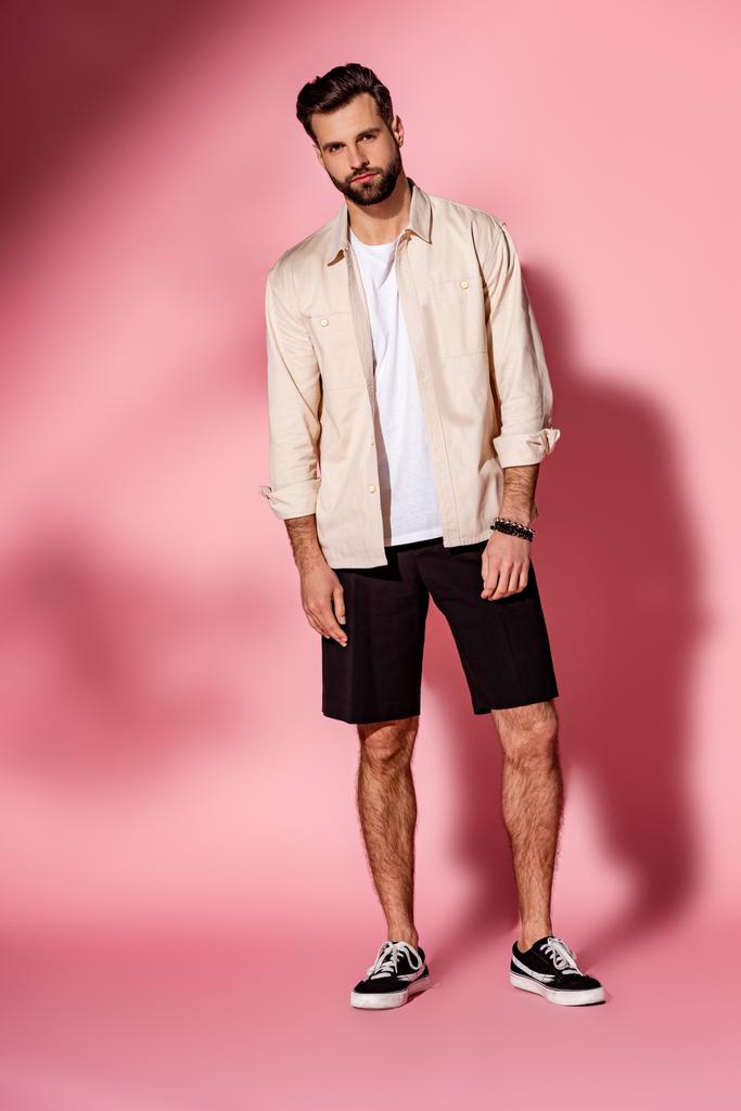 elegante hombre barbudo guapo posando en camisa de verano y pantalones cortos en rosa
 - Foto, imagen