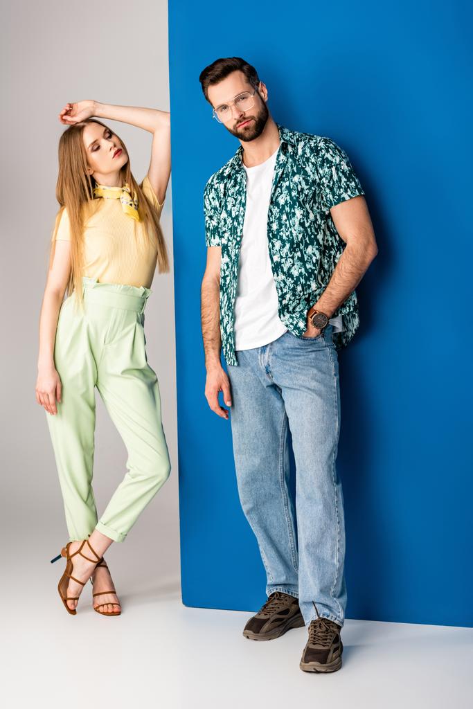 μοντέρνο νεαρό ζευγάρι ποζάρουν σε καλοκαιρινά ρούχα σε γκρι και μπλε  - Φωτογραφία, εικόνα