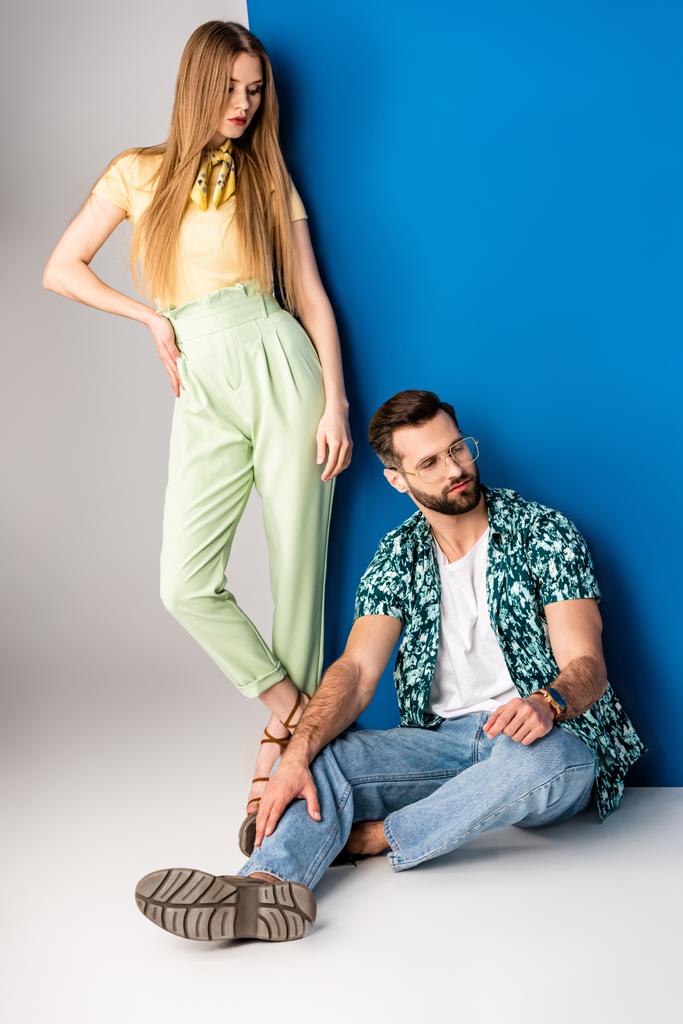 красивая стильная пара, позирующая в летней одежде на сером и синем
  - Фото, изображение