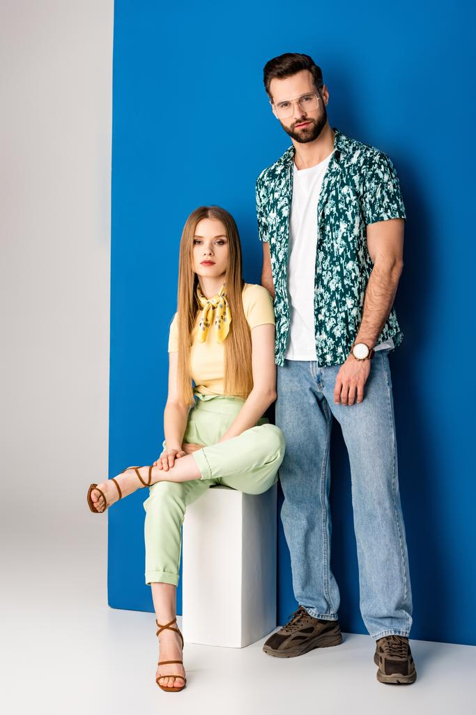 coppia alla moda posa in abiti estivi su grigio e blu
  - Foto, immagini
