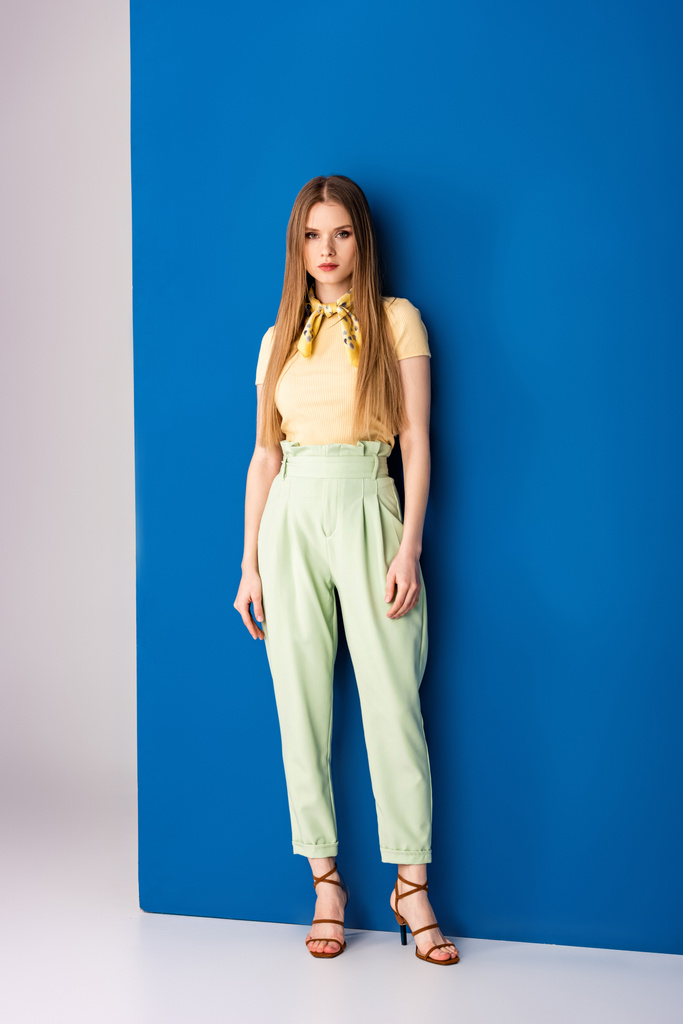 divatos lány pózol zöld nyári nadrág és sarok szandál szürke és kék - Fotó, kép