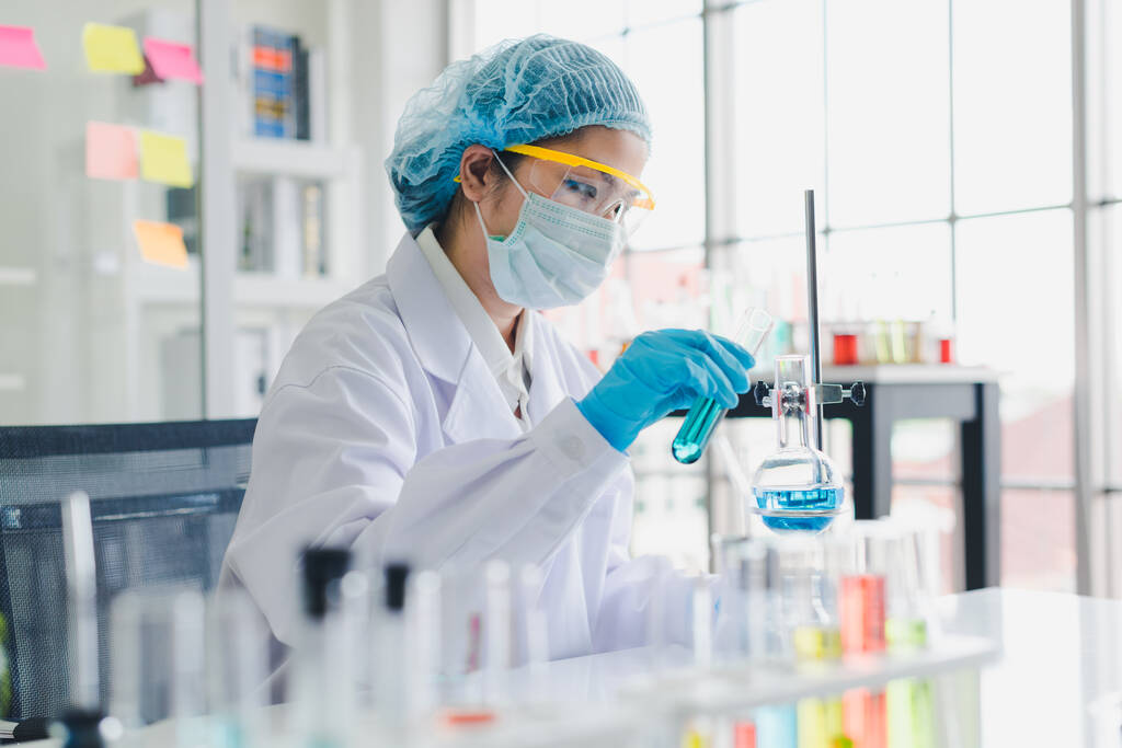 Asiatische Wissenschaftler testen und analysieren viele Chemikalien im Labor. Wissenschaft und chemische Konzepte. - Foto, Bild