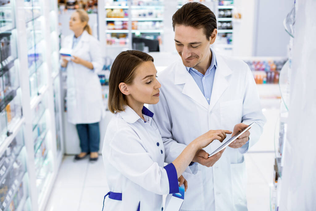 Deux pharmaciens vérifient la disponibilité des médicaments dans une pharmacie
. - Photo, image