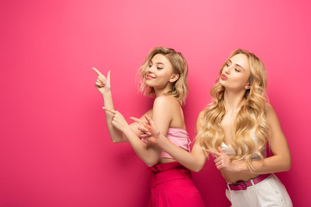 Belles femmes blondes pointant sur fond rose avec espace de copie
 - Photo, image