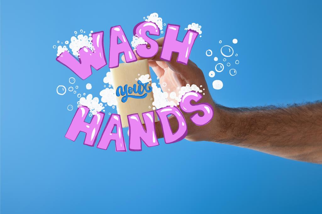bijgesneden weergave van de mens houden zeep geïsoleerd op blauw, wassen handen illustratie - Foto, afbeelding