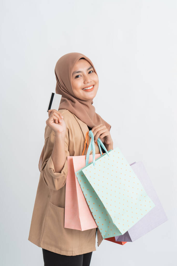 Muslimische Frau hält Einkaufstasche auf weißem Grund - Foto, Bild