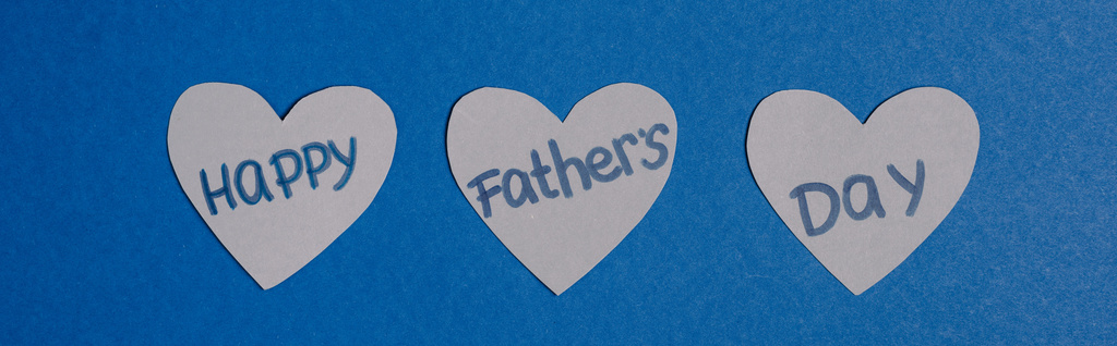 Panoramaaufnahme von grauen Papierherzen mit Schriftzug Happy Vatertag auf blauem Hintergrund - Foto, Bild