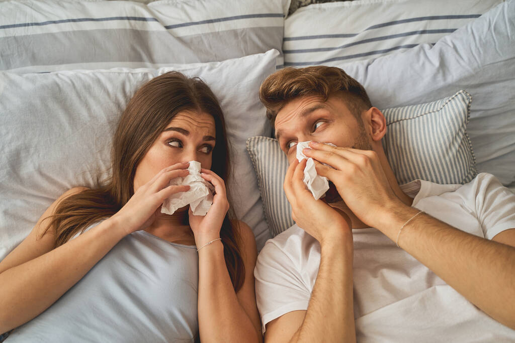 Άρρωστος άντρας και γυναίκα σκουπίζουν τις μύτες τους - Φωτογραφία, εικόνα