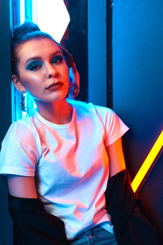 Retrato de una chica con iluminación de neón. Hermosa chica en un estudio con luz de color
. - Foto, Imagen