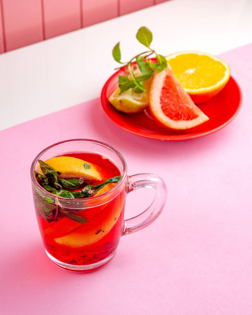 té de frutas vista lateral con menta de naranja limón y pomelo en la mesa
 - Foto, imagen