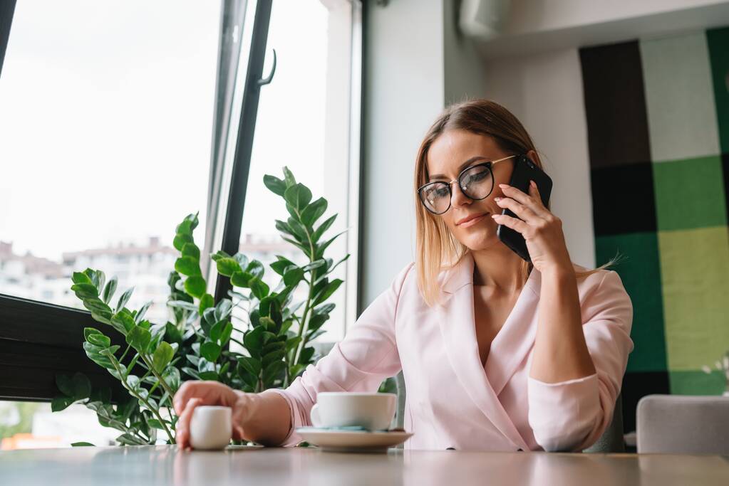 gyönyörű üzleti hölgy iszik kávét, és használja a különböző szerkentyű - Fotó, kép