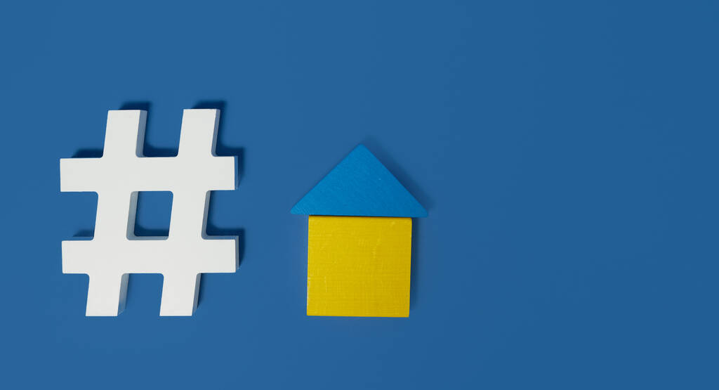 Restez à la maison concept. Symbole de hashtag et figurine d'une maison en bois sur fond bleu. Zone vide pour le texte
. - Photo, image