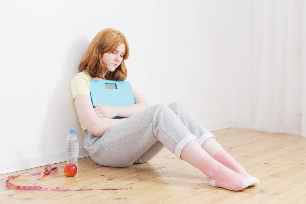 smutné dospívající dívka s měřítkem na dřevěné podlaze - Fotografie, Obrázek