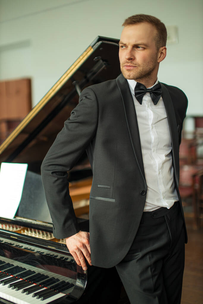 Porträt eines gutaussehenden Pianisten, der vor der Kamera posiert - Foto, Bild