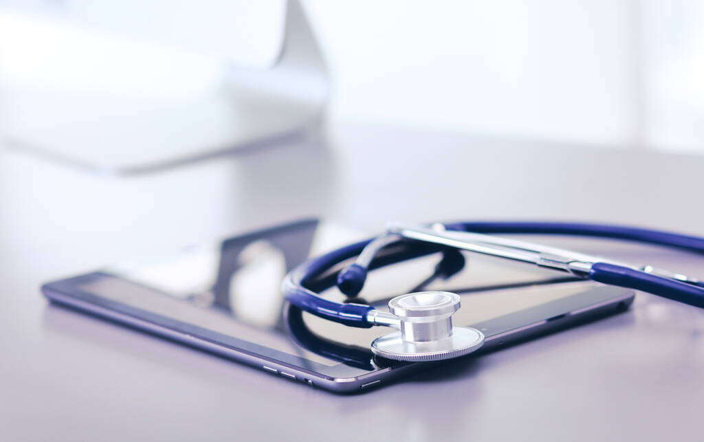 Tıbbi ekipman: Beyaz zemin üzerinde mavi steteskop ve tablet - Fotoğraf, Görsel