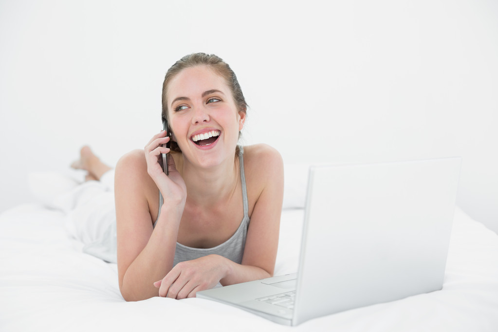 fröhliche, lässige Frau mit Handy und Laptop - Foto, Bild