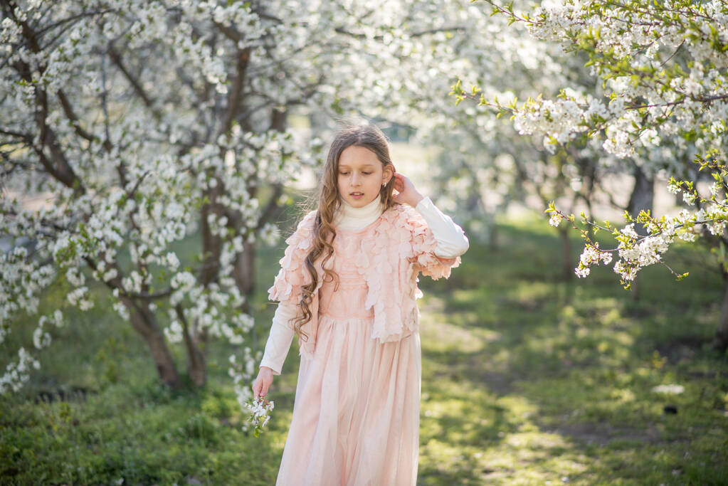 niña vistiendo vestido rosa en el jardín de primavera - Foto, Imagen