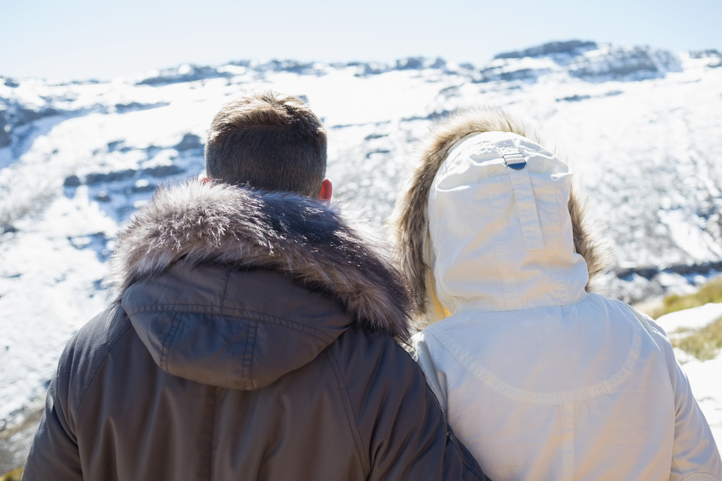 ζευγάρι με σακάκια κοιτάζοντας χιονισμένες οροσειρά - Φωτογραφία, εικόνα