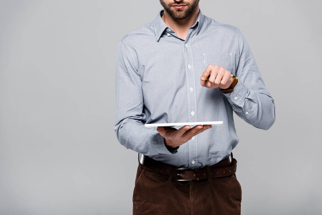 обрезанный вид бородатого бизнесмена, указывающего пальцем и держащего цифровой планшет, изолированный на сером
  - Фото, изображение