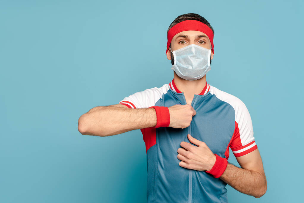 stylish sportsman in medical mask on blue background - Photo, Image