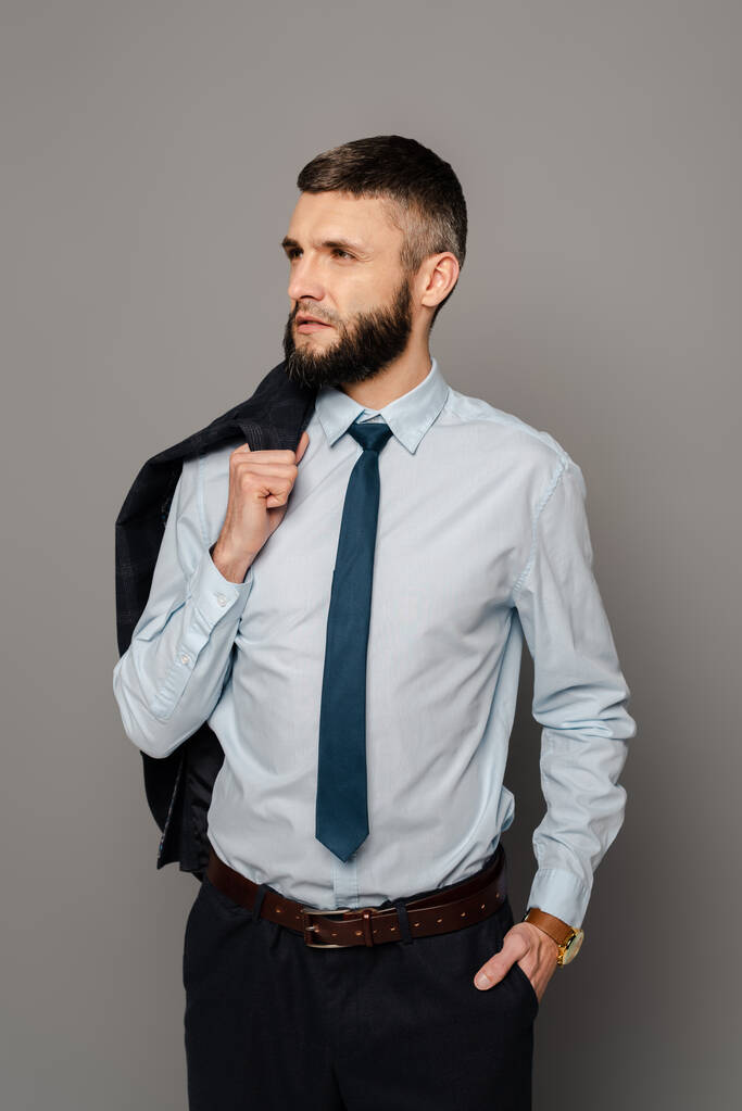 guapo barbudo hombre de negocios con chaqueta sobre fondo gris
 - Foto, Imagen