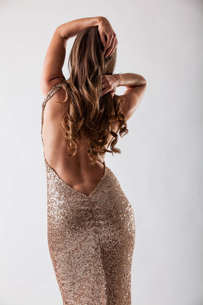 Schöne elegante junge Frau im modischen goldenen Abendkleid - Foto, Bild
