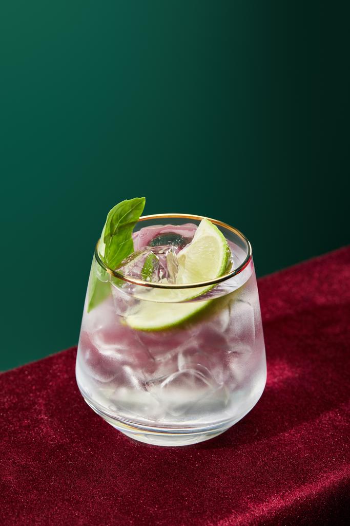 високий кут зору освіжаючого мохіто з м'ятою та льодом у склі з золотим фланцем ізольовані на зеленому
  - Фото, зображення