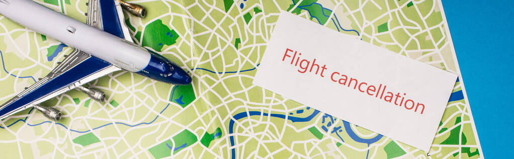 Horní pohled na kartu se zrušením letu v blízkosti hraček letadlo na mapě izolované na modré, panoramatický záběr - Fotografie, Obrázek