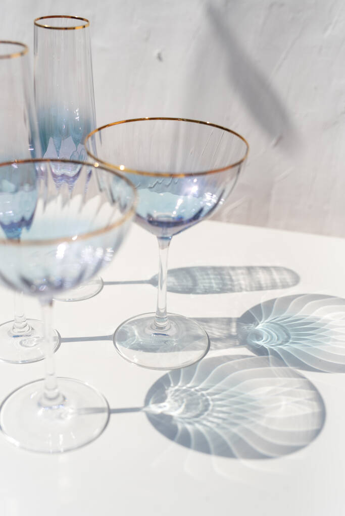 blauw transparant cava glas set met zonlicht reflecties - Foto, afbeelding