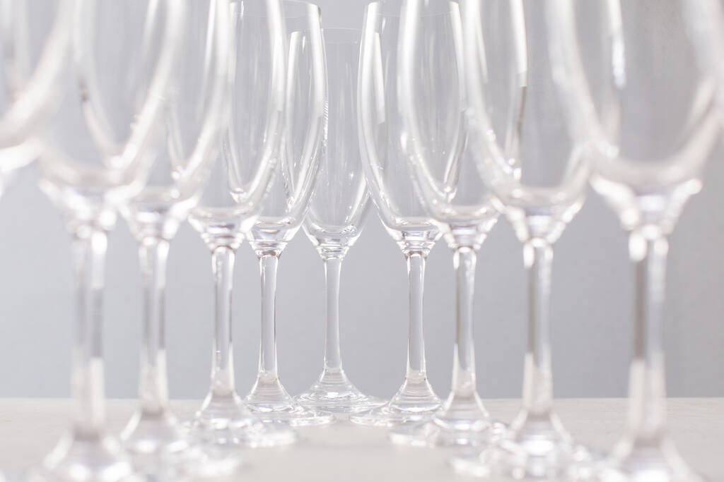 Glas voor champagne op grijze achtergrond, glazen schotels voor drankjes zijaanzicht - Foto, afbeelding